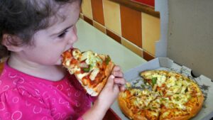 Niño aprendiendo a comer verduras en casa