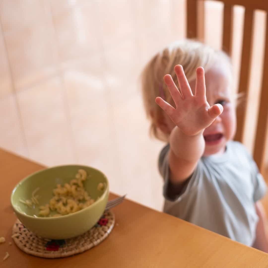 Niño pequeño rechazando la comida a la hora de comer