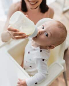 niño tomando leche en el biberón
