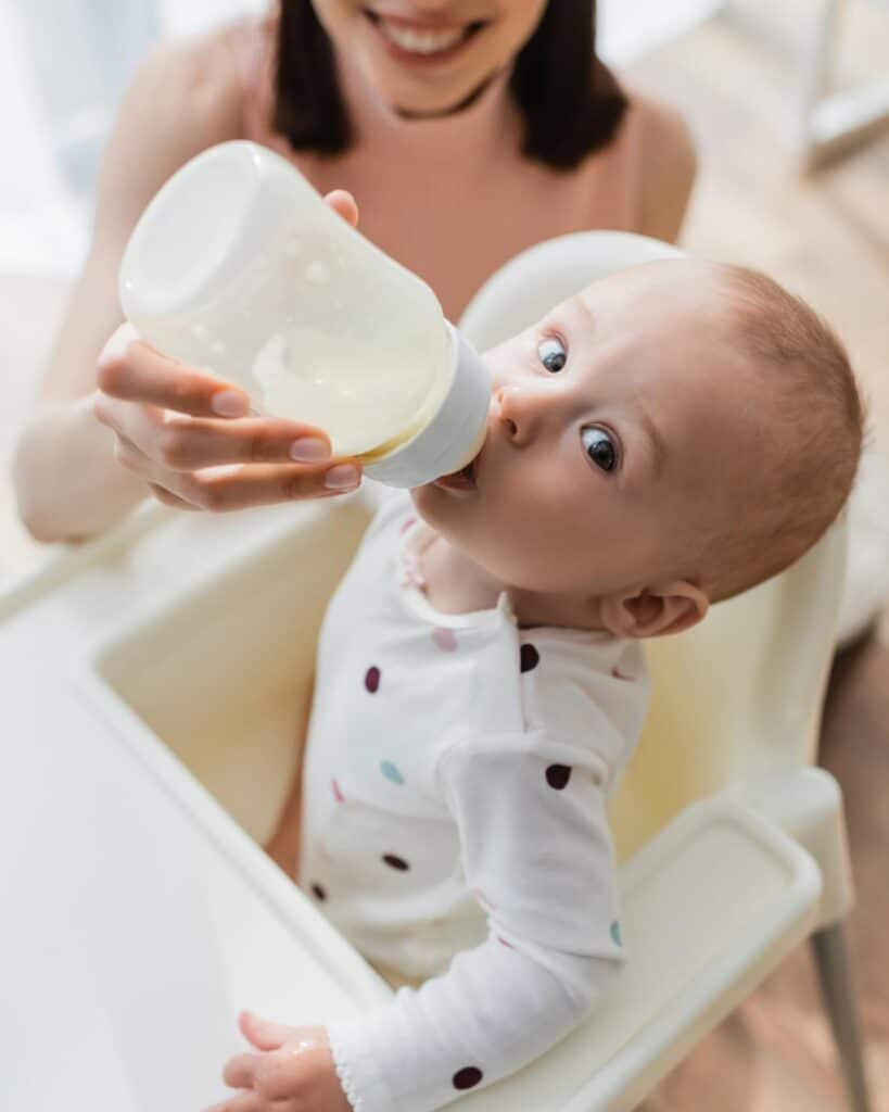 niño tomando leche en el biberón