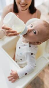 niño tomando leche en el biberón